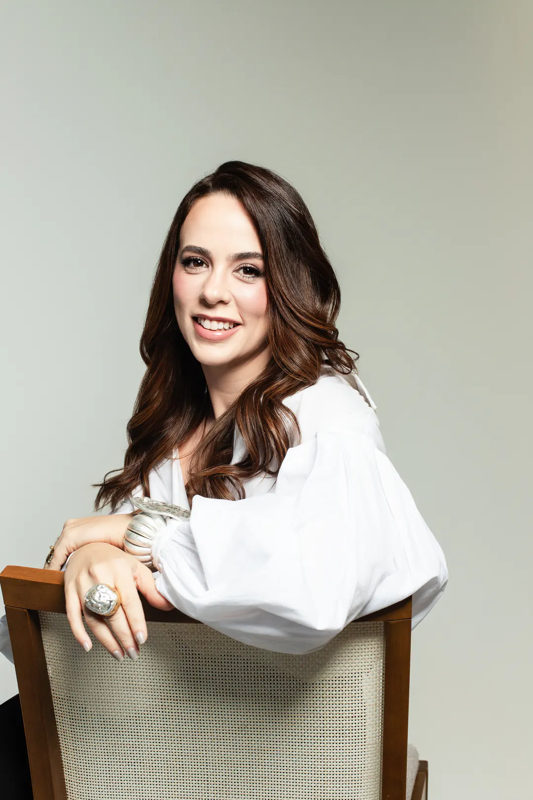 Dra. Amanda Medeiros sentada, sorrindo