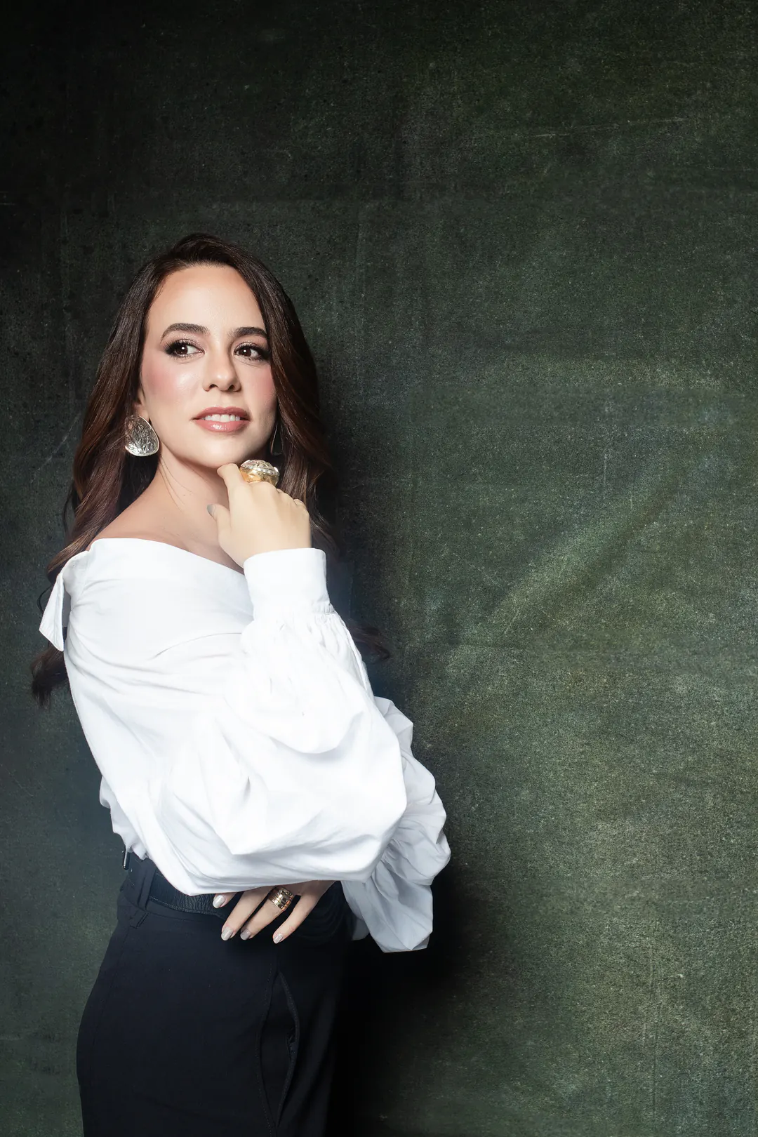 Dra. Amanda Medeiros, dermatologista, em retrato sobre fundo verde
